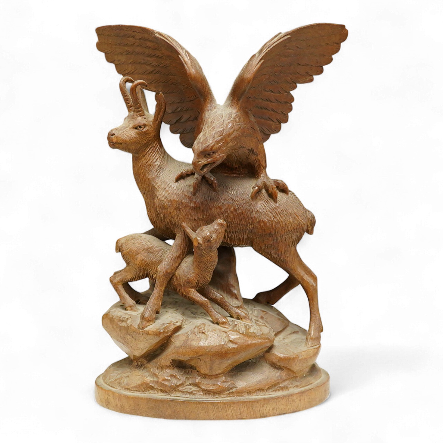 A late 19th century Black Forest carving, chamois group and eagle, 21cm